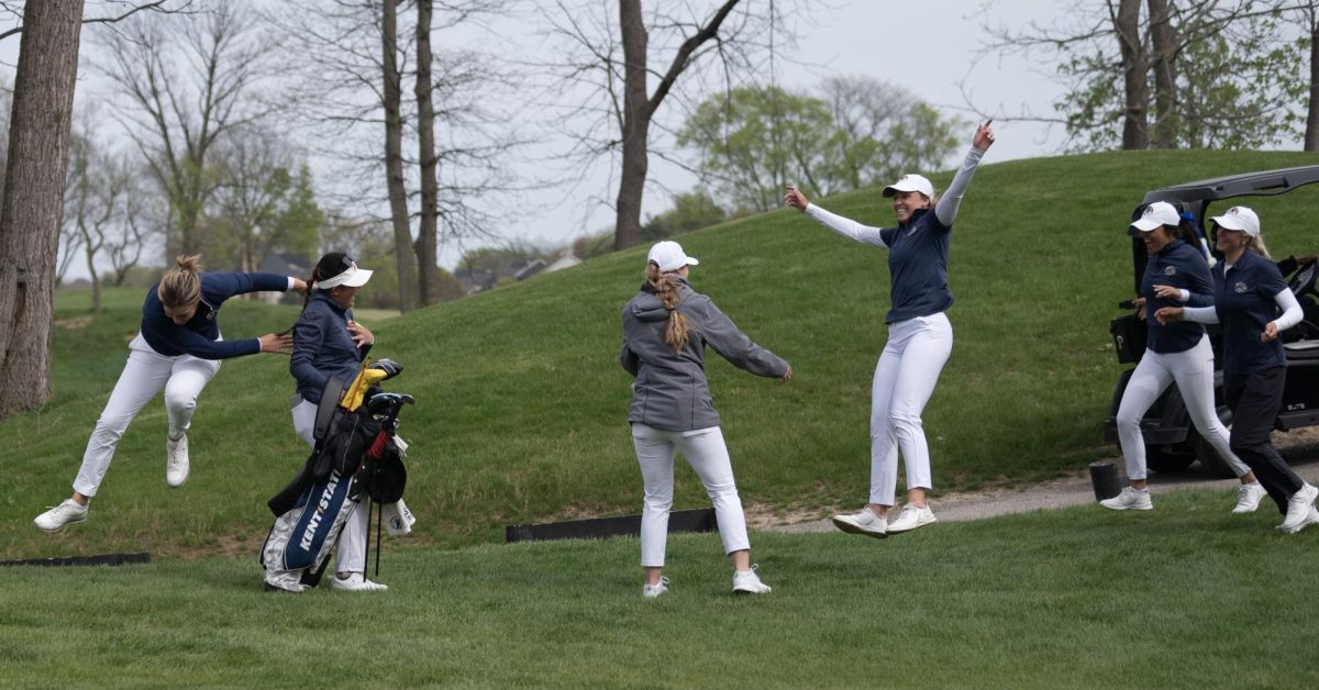 The team cheers and rushes Leon Takagi, second from left, after Takagi leaves the green on 18 following the 