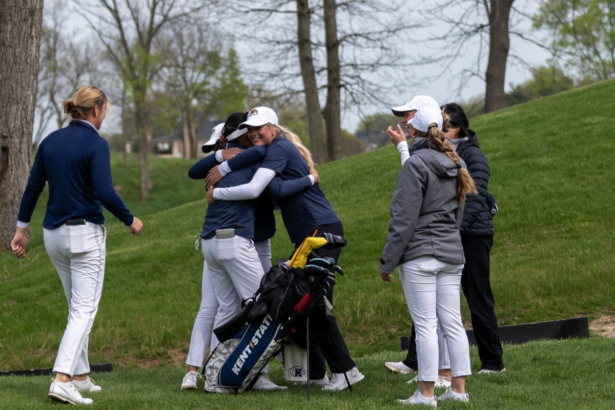 Kristen Belden, center, and another teammate hug Leon Takagi after Takagi's putt on 18 following the final round of the Mid-American Conference Championships in Grove City, OH, on April 24, 2024.