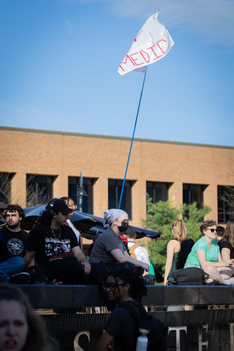 People sit on the Kent State sign outside of the student center during the Rittenhouse event on April 16, 2024.