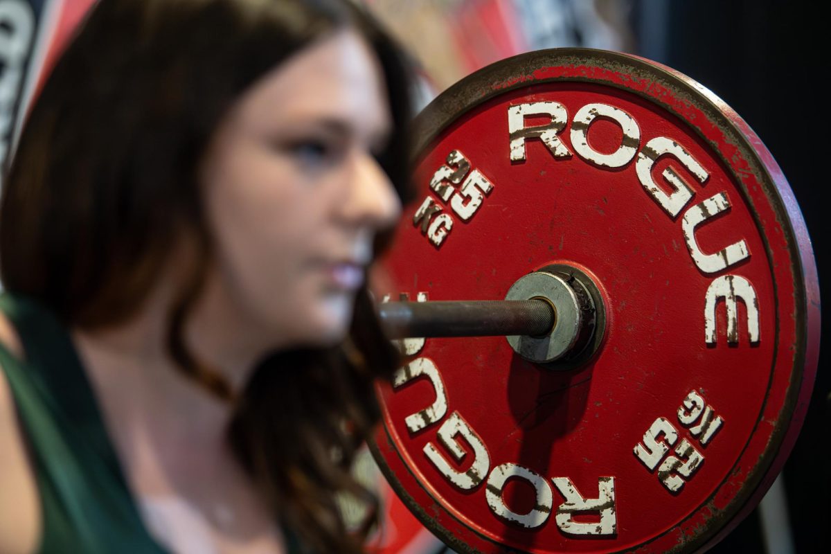 Kent senior musical theator major Ariel Brinker squats at Kent Barbell Club, Wednesday, Sept. 25, 2024. Brinker says she enjoys lifting because it helps keep her body strong for dancing and gives her a fun fact to discuss during interviews.