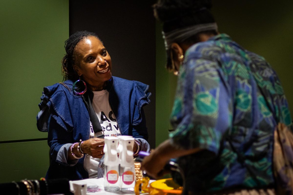 Day Watson looks at the wares of Zebulun DeGrate owner of Orange Moon at the Black Alumni Chapter Homecoming Marketplace and Dance on Sept. 27, 2024.