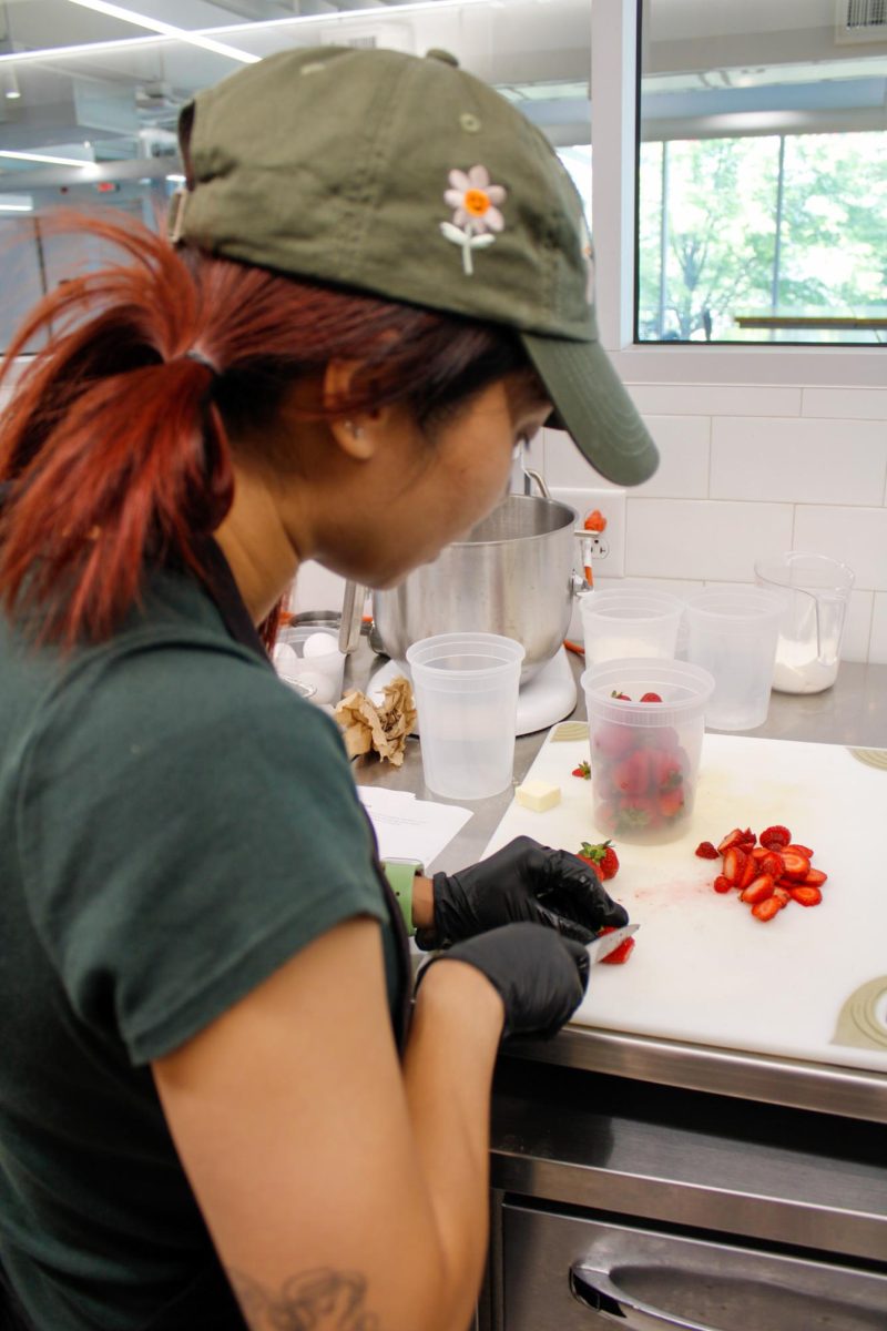 Junior, Tiffany Lai cutting up strawberries for her recipe, strawberry crumble muffins during a culinary class in the DI Hub on September 13, 2024. 