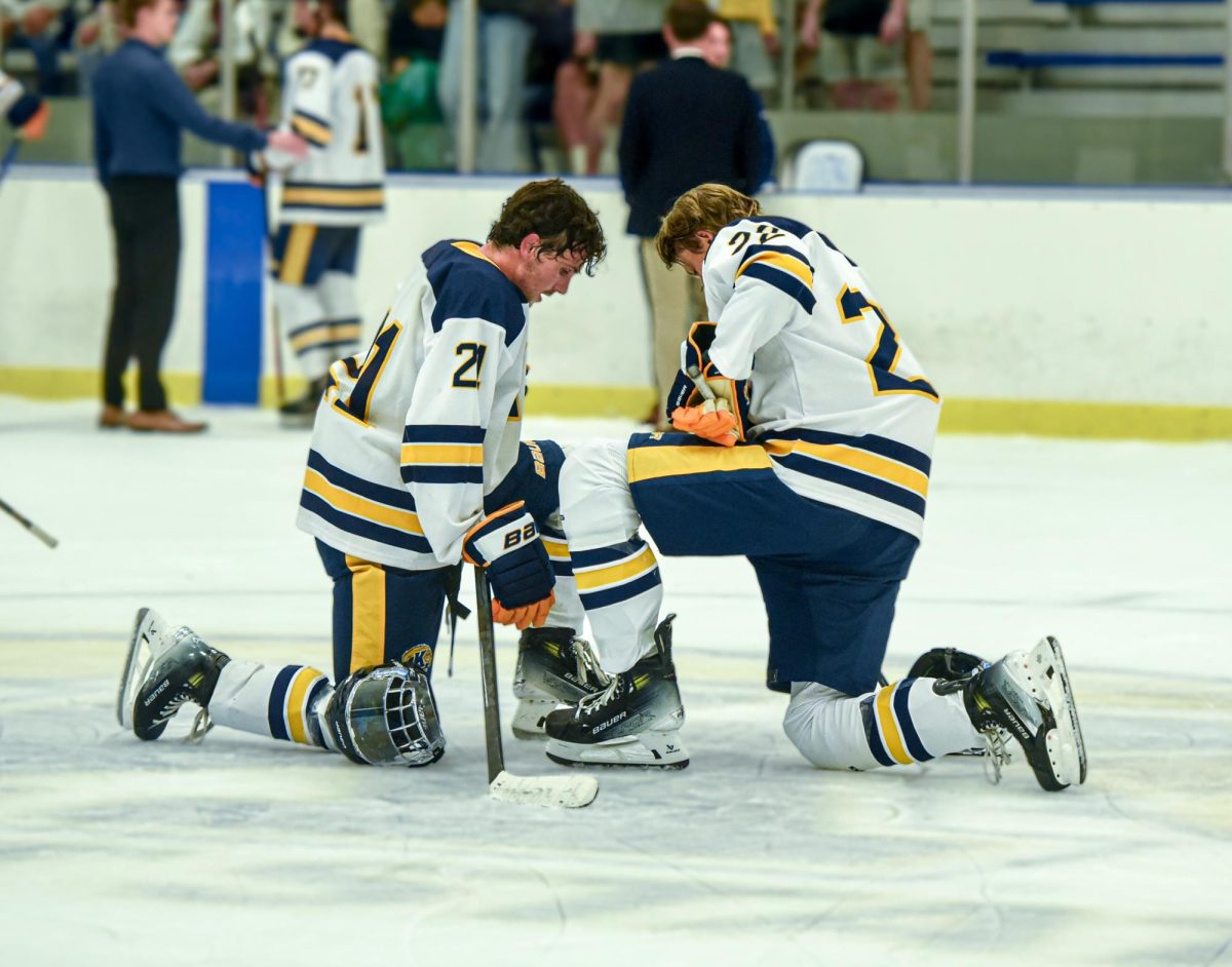 TJ Avelino (left), Kent sophomore and Ice Hockey forward kneels on the ice with Chaseton Sieling (right), Kent freshman and Ice Hockey defensemen, to pray after their 4-2 win against Northern Illinois. Sept. 14th, 2024.