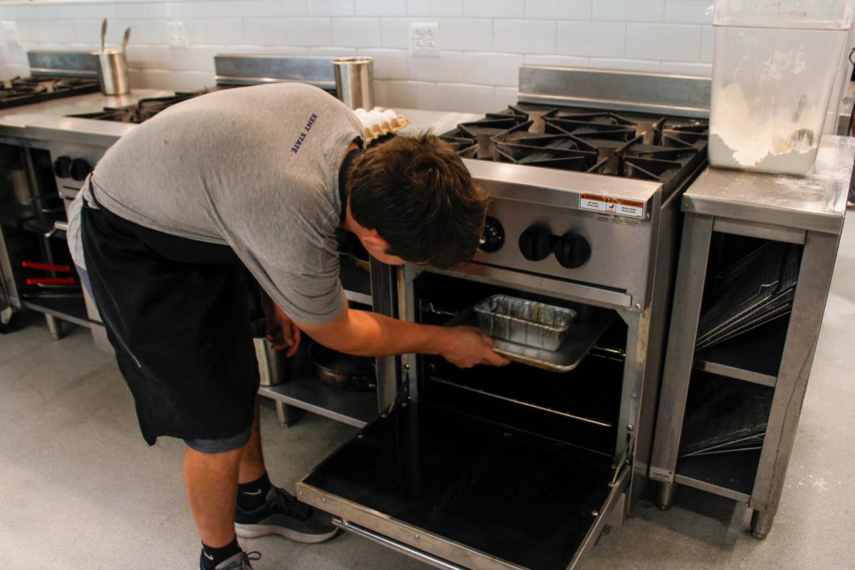 Sophomore, Nate Bergdorf putts zucchini dough in the oven during a culinary class in the DI Hub on September 13,2024. 