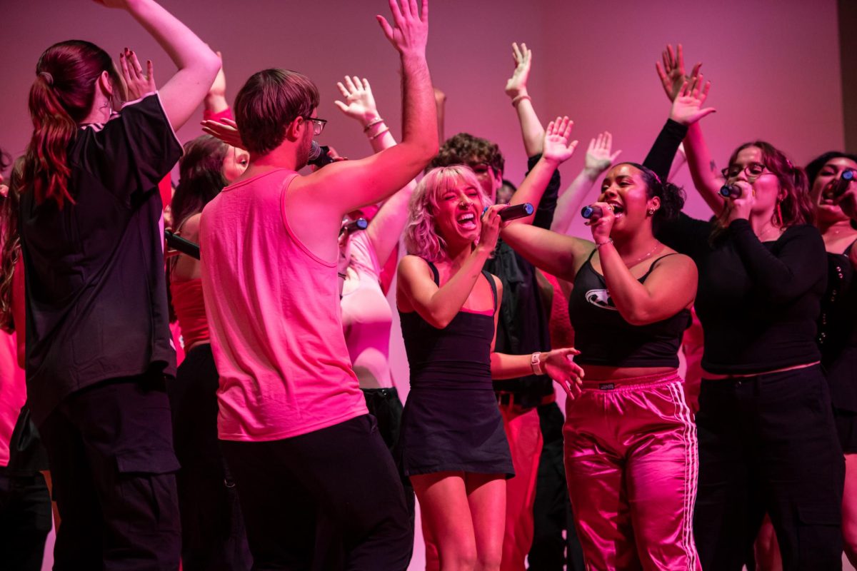 Fourth year music education major and Vocal Intensity music director Melaina Uhrig, center, sings alongside other Vocal Intensity members at the KIVA during their Bring the Beat In concert, Friday, Nov. 22, 2024.