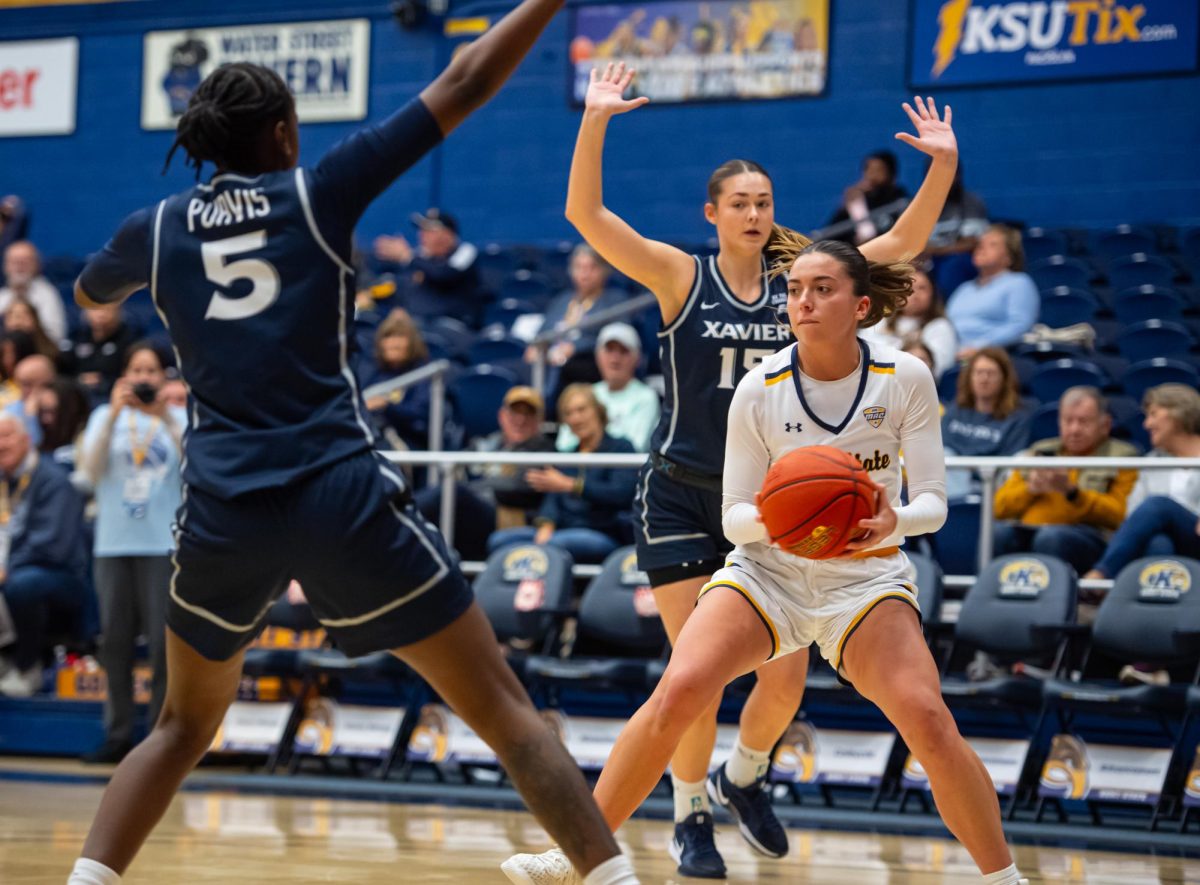 Kent sophomore Mya Babbitt, 23, looks for an open teamate to pass the ball too during first quarter of the game against Xavier, Saturday, Nov. 23, 2024.