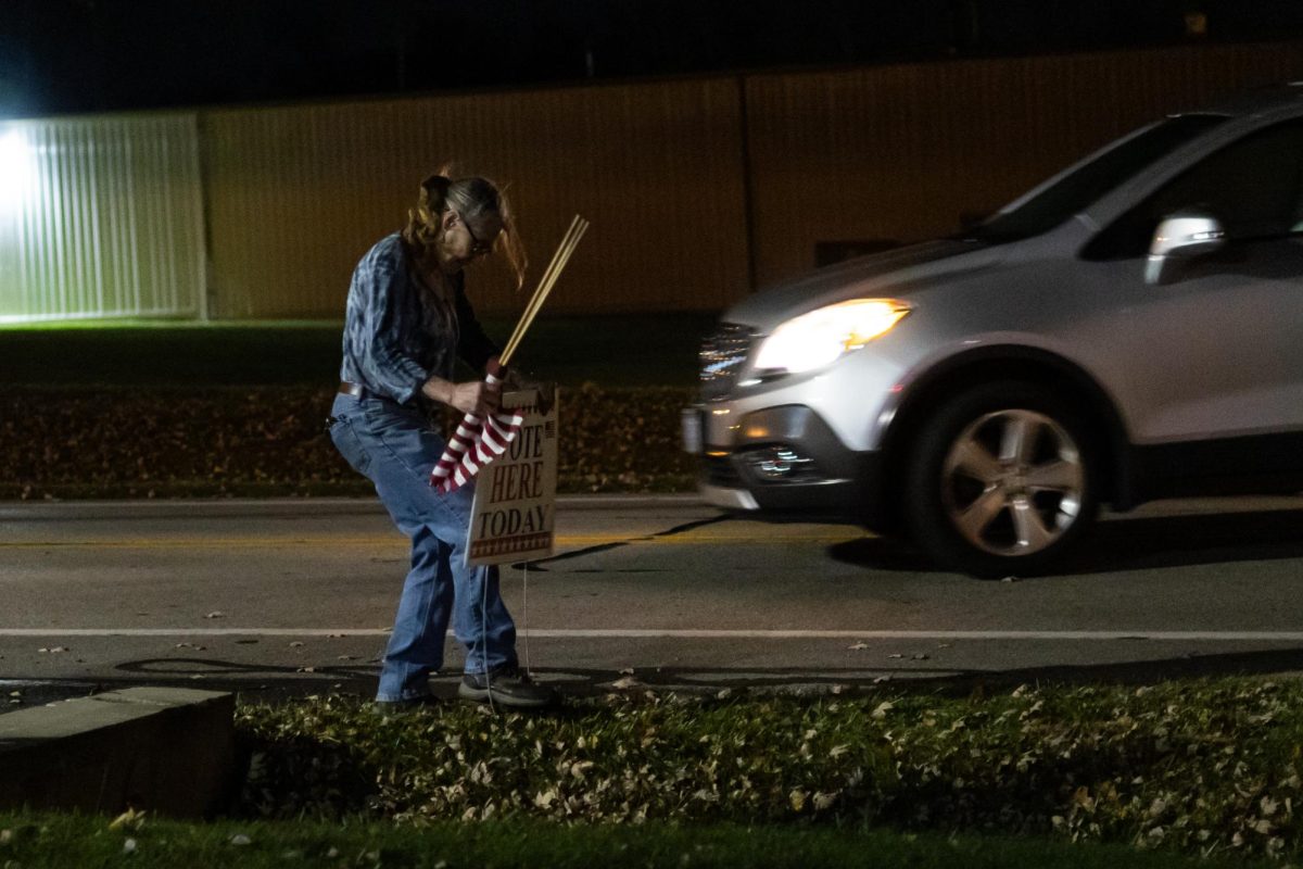 Jean Reid, a poll worker, is placing the sign to signal to others that the Ravenna Elk Lodge is a voting location on Nov. 5th, 2024.