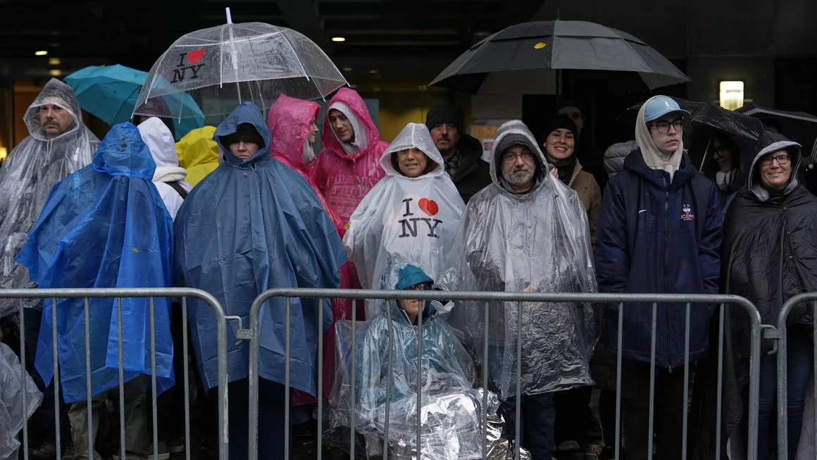 Macy's Thanksgiving Day Parade attendees wait for festivities to begin in the cold rain Thursday.