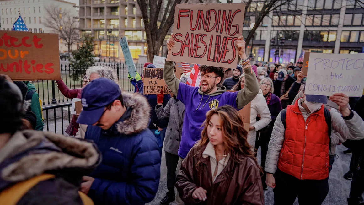 People gather during a rally in support of federal funding and in opposition to President Donald Trump's order to pause all federal grants and loans, near the White House in Washington, DC, on January 28.