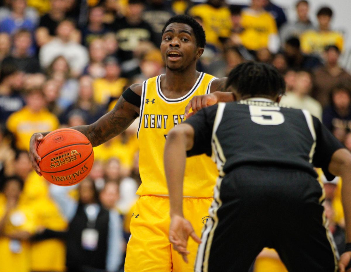 Kent State University sophomore guard Cian Medley, 11, dribbling the ball down the court while University of Akron junior guard Tavari Johnson, 5, gets ready to block him during their match on Jan. 31, 2025. 