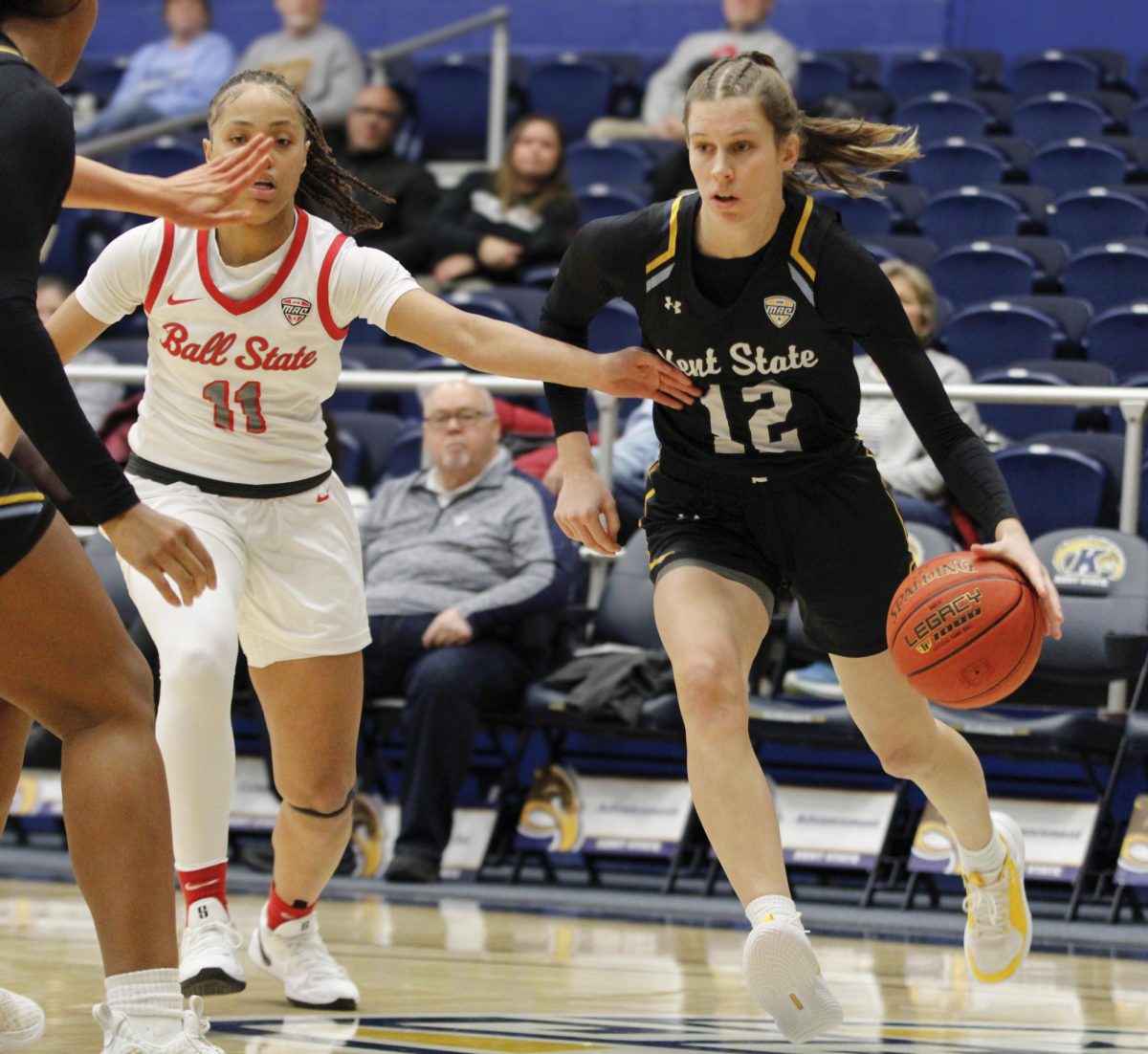 Kent State University senior guard Jenna Batsch dribbling the ball going through a block by Ball State senior Lachelle Austin in their match against Ball State University, Jan. 15, 2025.