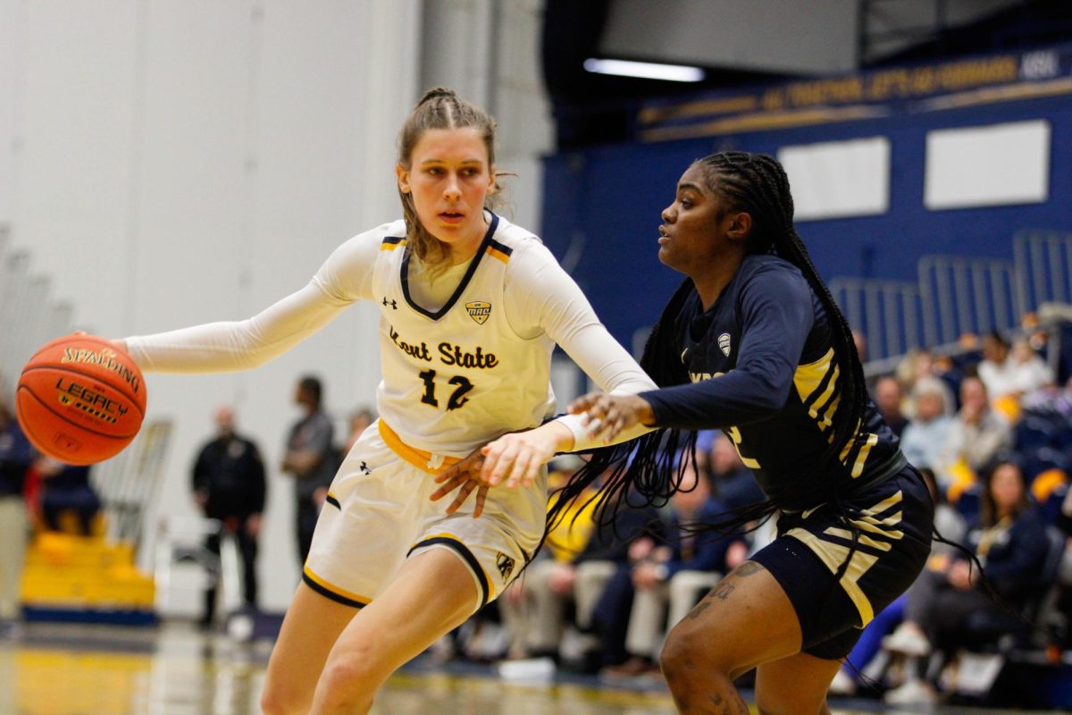 Kent State University senior guard Jenna Batsch, 12, dribbles the ball as Akron University senior guard Alexus Mobley, 2, guards her in their game on Feb 1, 2025. 