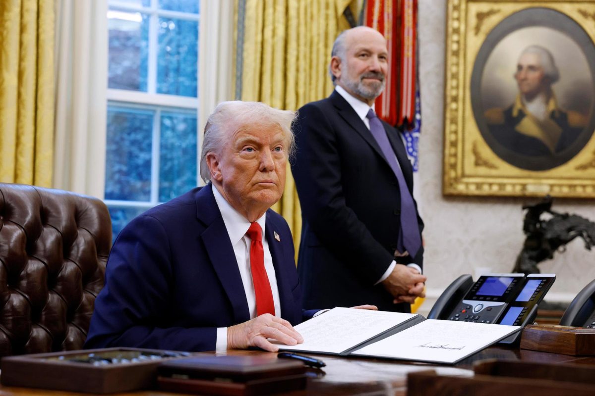 President Donald Trump, alongside Howard Lutnick, his nominee for Commerce Secretary, speaks to reporters in the Oval Office of the White House on February 3, in Washington.