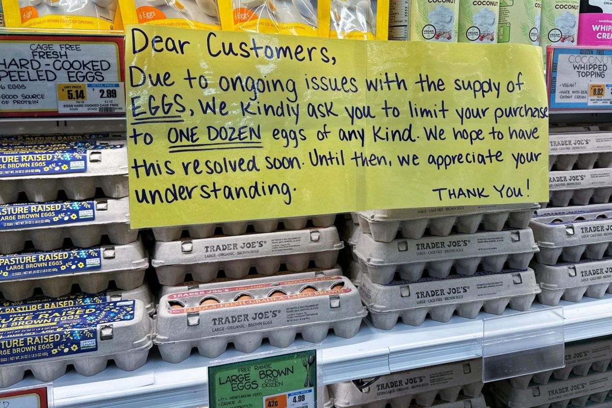 A sign for customers shopping for eggs at Trader Joe's hangs by cartons of eggs in in a New York store.