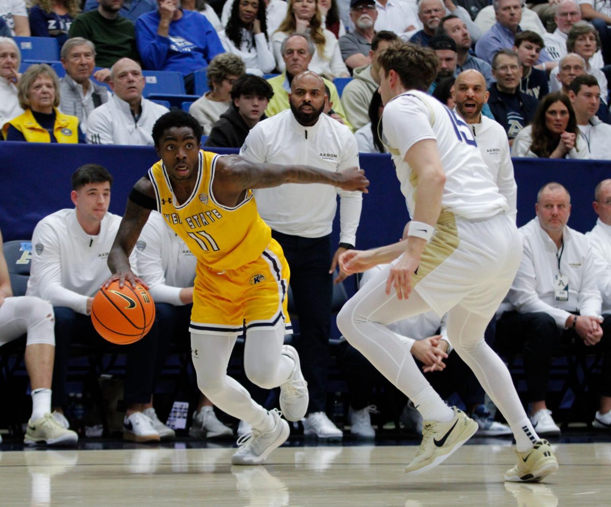 Kent sophomore Cian Medley, 11, dribbles the ball down the court as Akron junior Bowen Hardman defends him in the first half of their game on Friday, Feb. 28, 2025. 