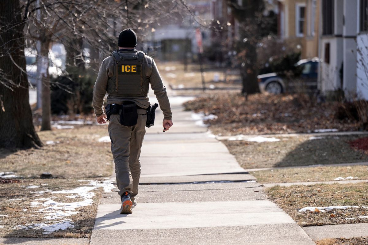 A US Immigration and Customs Enforcement (ICE) agent walks down a street during a multi-agency targeted enforcement operation in Chicago, Illinois, US, on January, 26.