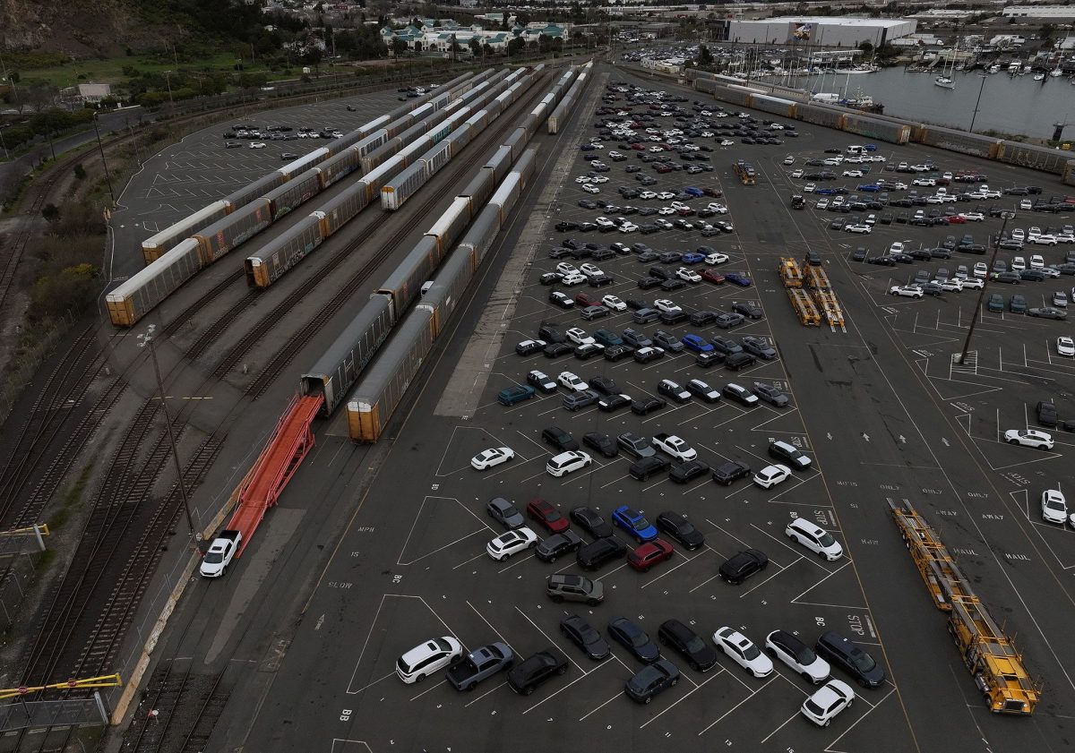 In an aerial view, brand new cars are taken off train cars at a rail yard on March 4 in Richmond, California.