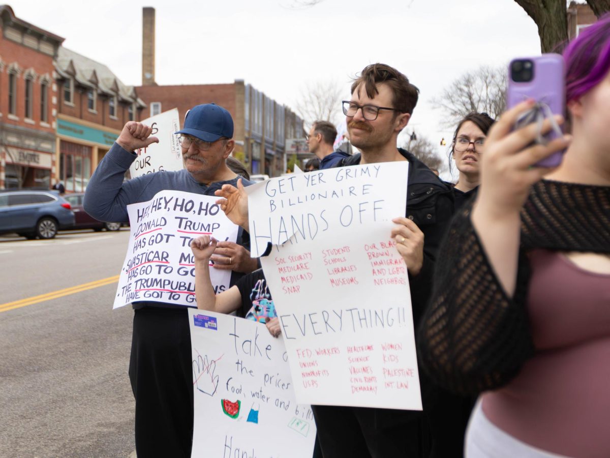 Protesters hold anti-Trump and anti-Elon signs at the Hands Off Protest, April 5, 2025, in Downtown Kent.