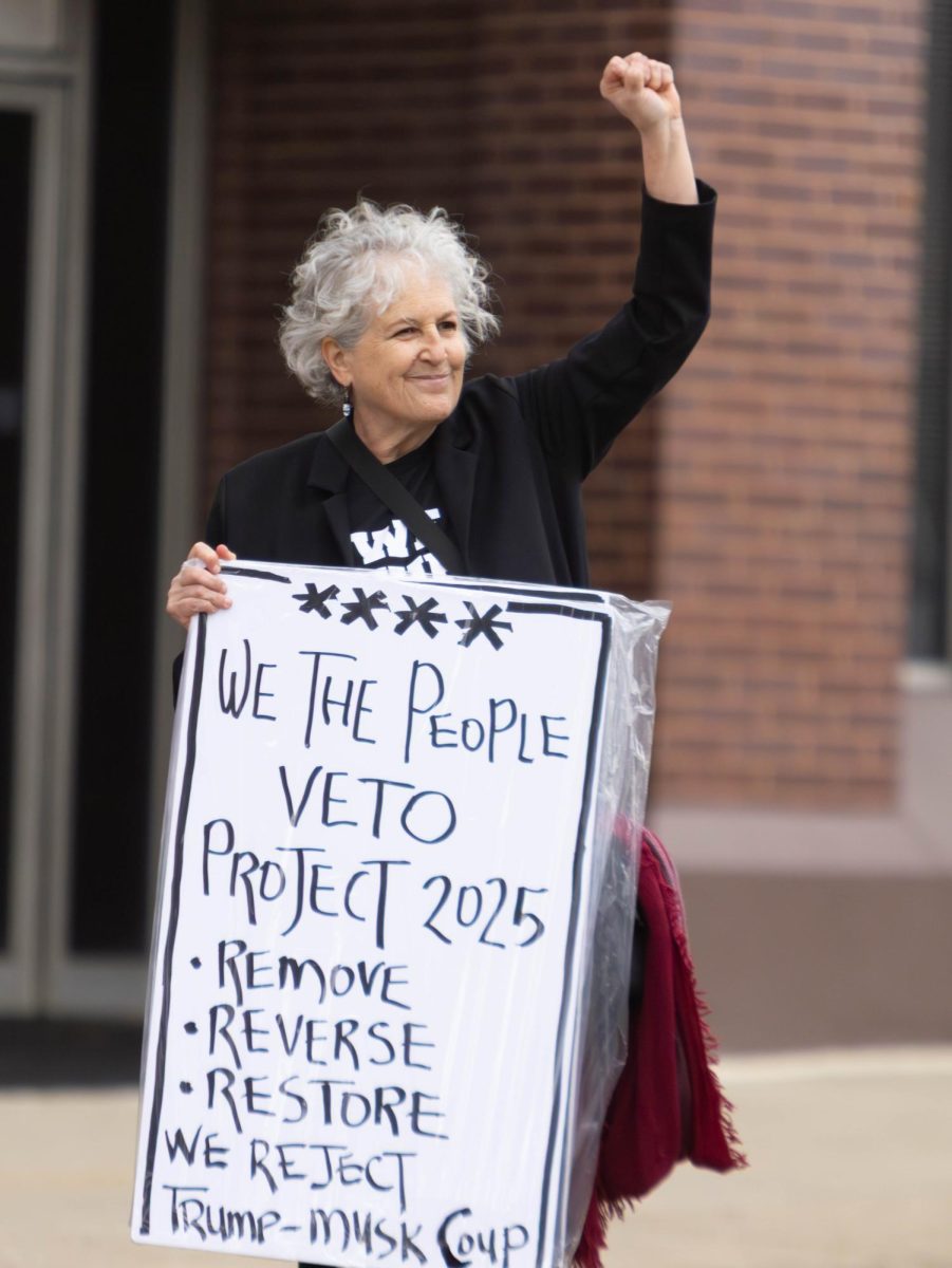 Kent resident Nina Gionti holds a sign at the Hands Off protest in Downtown Kent, April 5, 2025.
