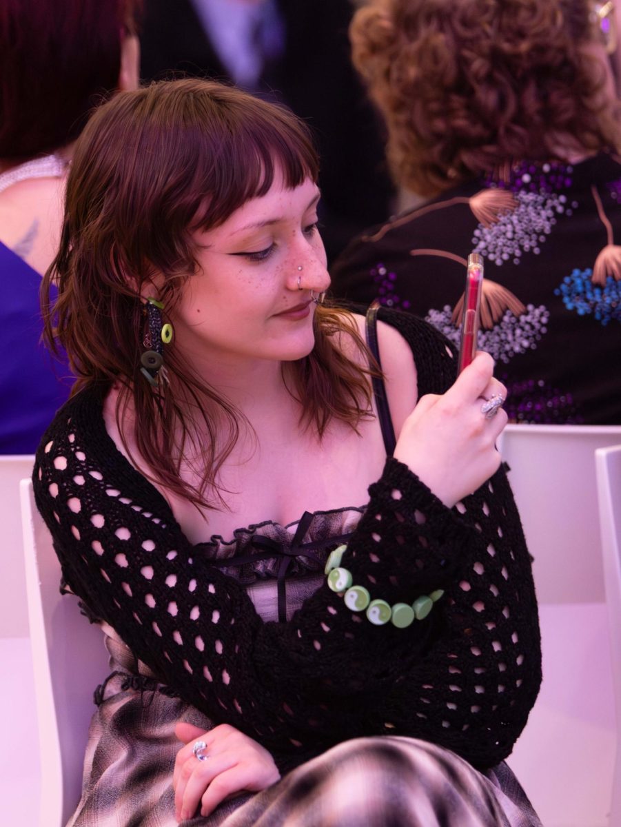 Senior fashion design major Roeyn Kalpac photographs the models wearing her designs at the annual fashion show, April 25, 2025.