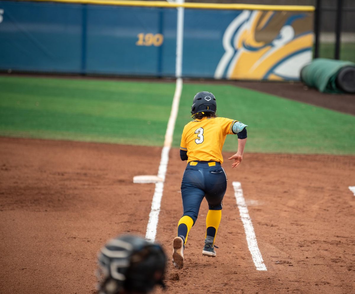 Kent junior Brynn Libler hits the ball to center field and runs to first base successfully during the game against Ball State on Saturday, April 5, 2025.
