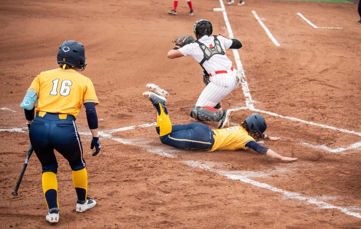 Kent junior Brynn Libler, 3, slides to score in the bottom of the first during their game against Ball State on Saturday, April 5, 2025. This made the score one to one, tying the game.