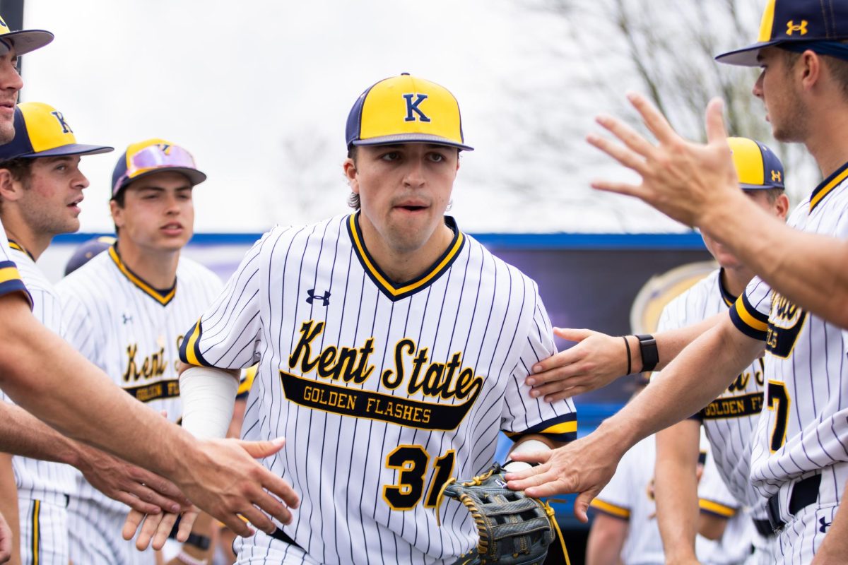 Kent graduate student, Hayden Jatczak, 31, runs out to the field as his teammates cheer him on before the start of their game against Akron on Friday, April 25, 2025. 