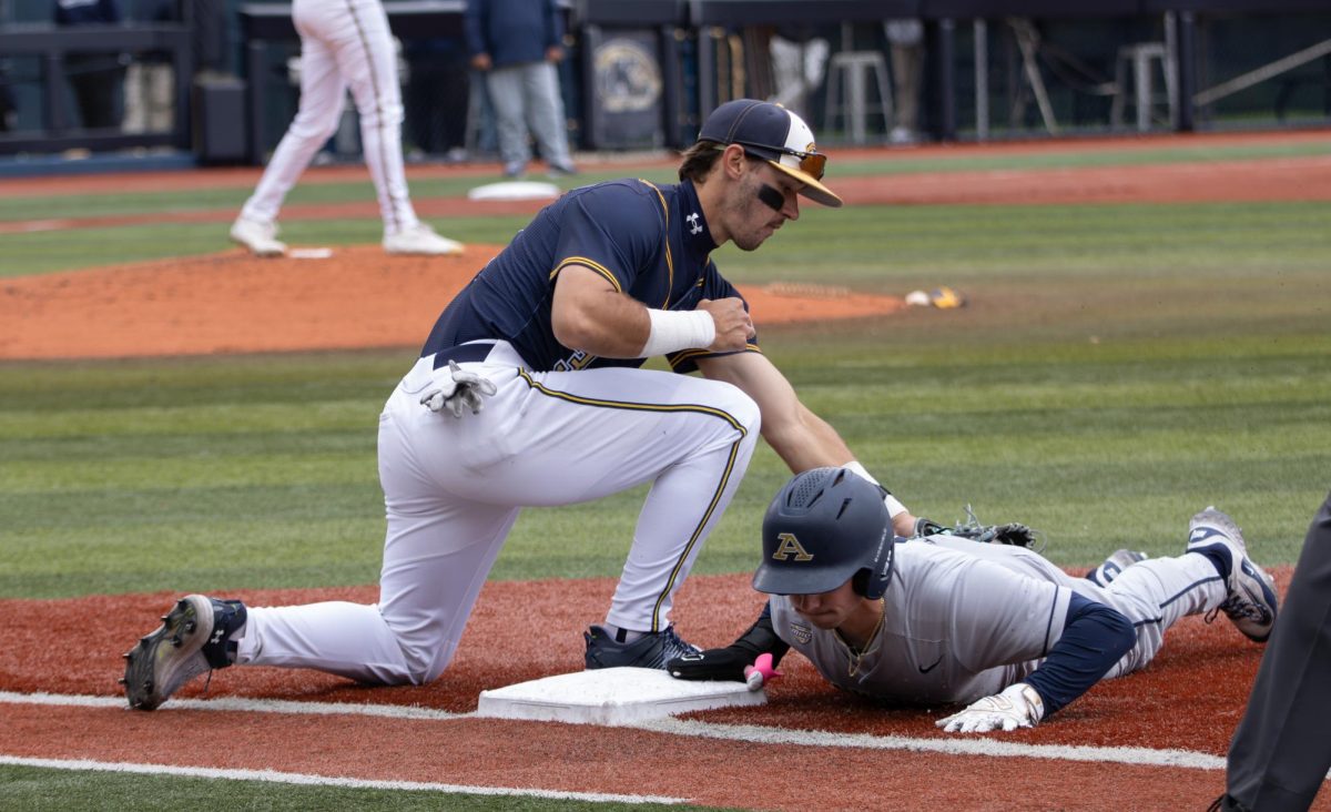 Kent senior Hunter Koltz tries to get Akron sophomore Austin Lafferty out on first base but fails to during the top of the fourth in their game on Saturday, April 26, 2025.