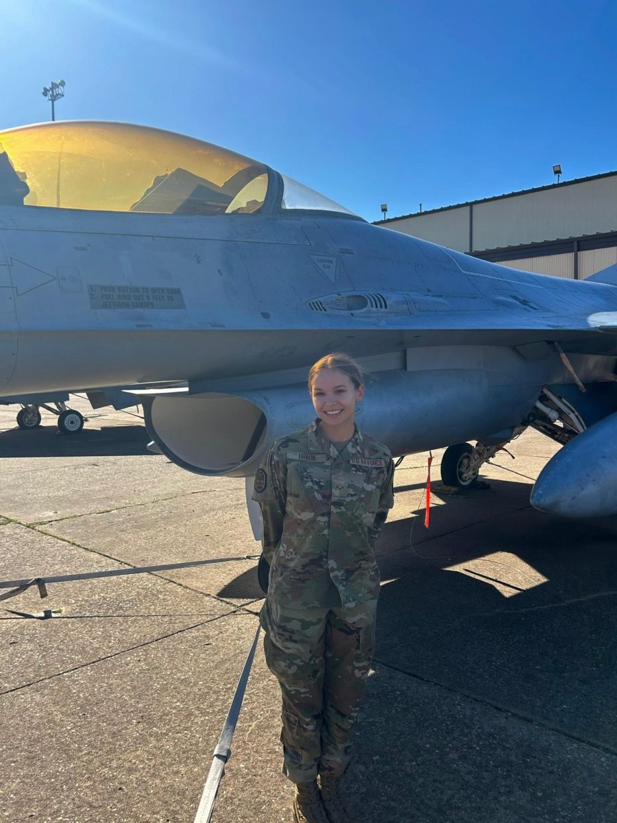 Lydia Braun standing in uniform in front of a military aircraft.