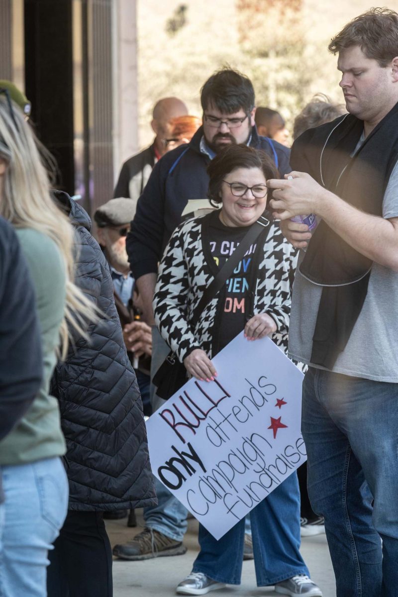 Melissa Becker holds a sign while she waits outside of the DeYor Performing Arts Center for Governor Tim Walz on April 7, 2025.