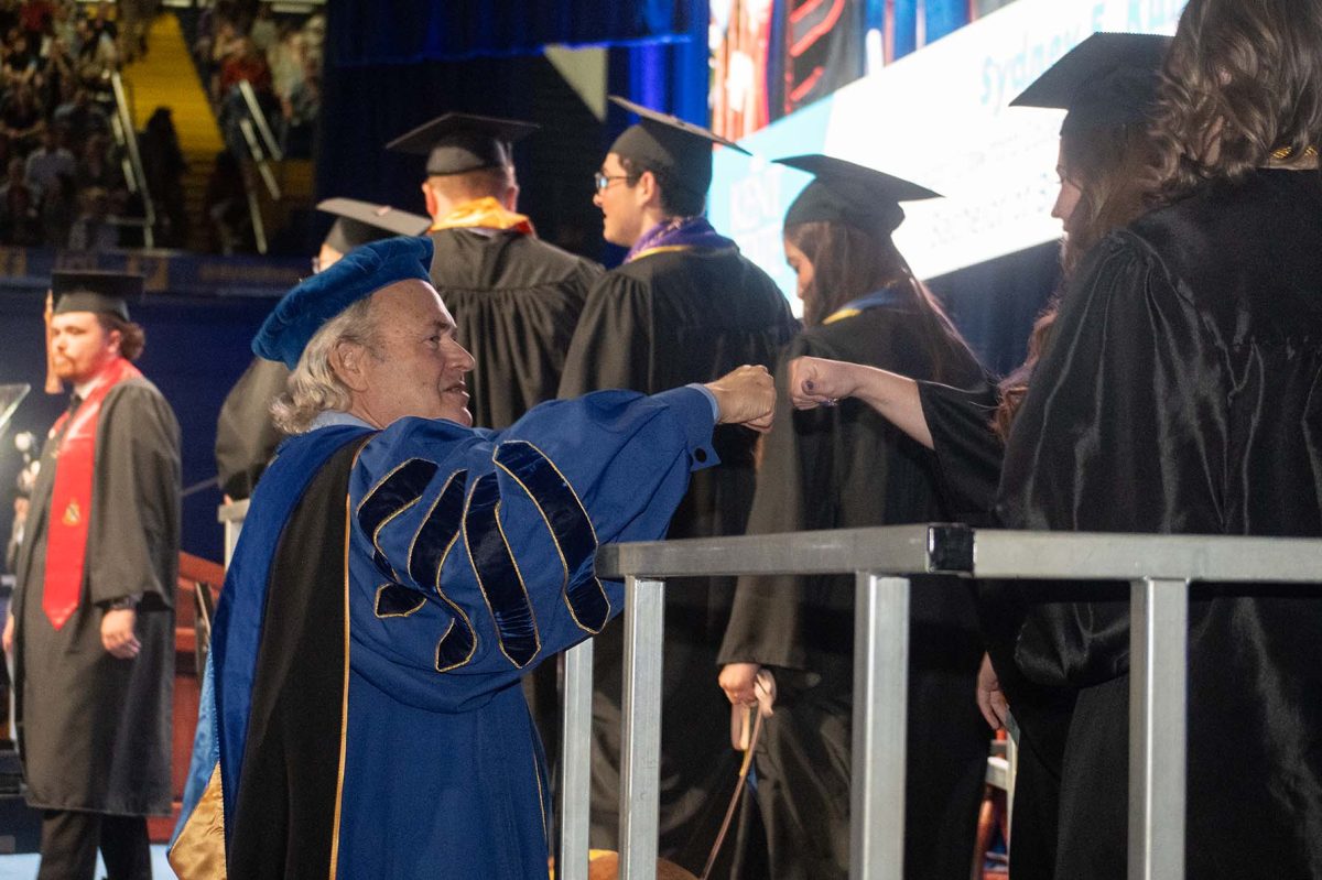 President Todd Diacon fist bumps students as they wait to get their diplomas on May 10, 2025.