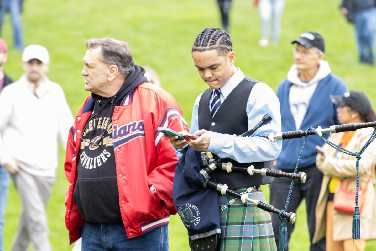 Columbus community member Brody Alexander (right), holds his bag pipe as he waits with his grandfather, Dean Mahovlic, for the May fourth commemoration to start at Taylor Hall on Sunday, May 4, 2025.