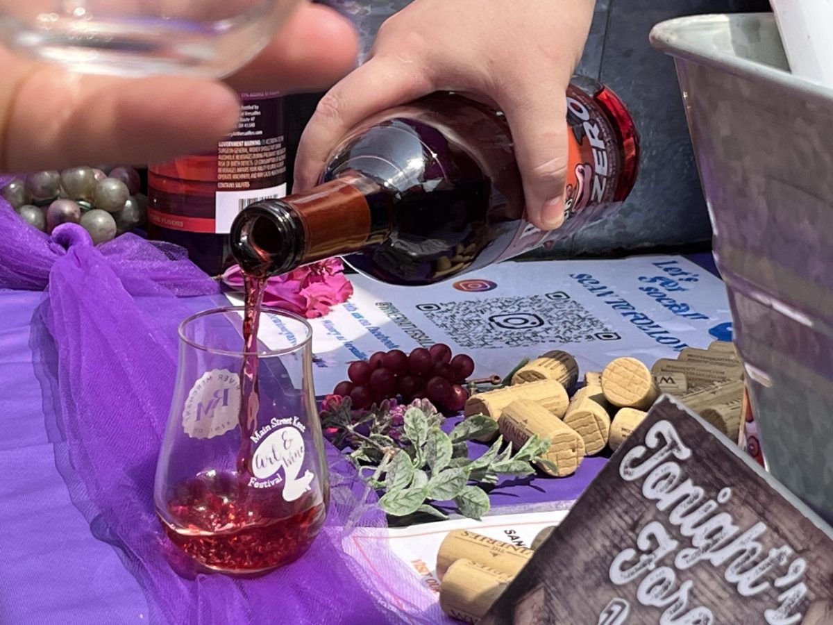 An employee at The Winery at Versailles pours the Red Rodeo wine for a customer at the Art and Wine Festival on Saturday, June 7, 2025. 