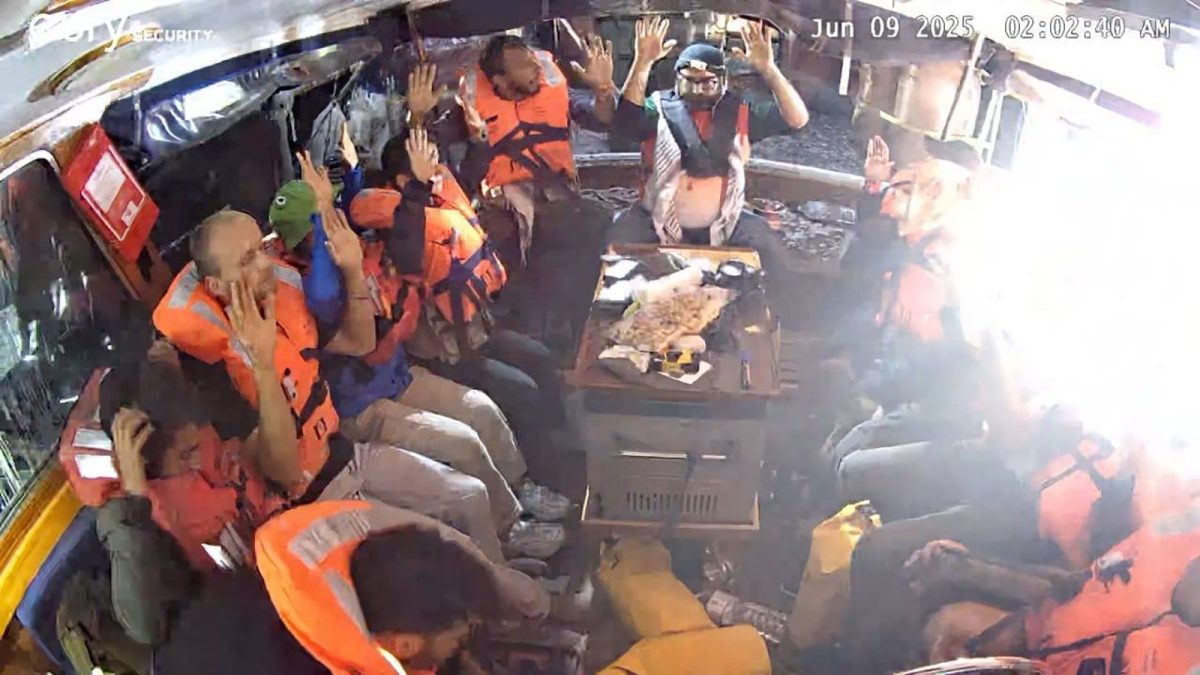 Crew members of the "Madleen" are seen with their hands in the air as Israeli forces come aboard, in this image from the Freedom Flotilla Coalition.