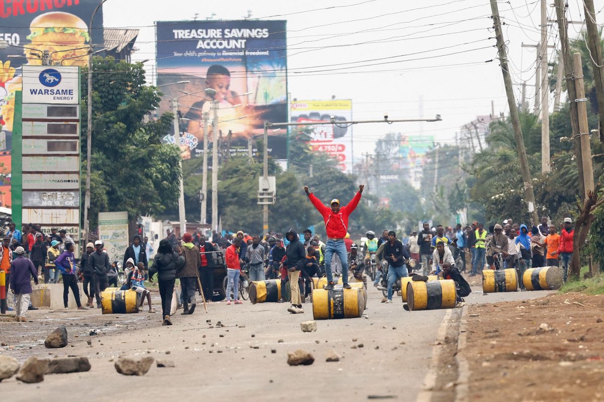 A demonstrator stands on a barricade cylinder during clashes with riot police in Nairobi on July 7.