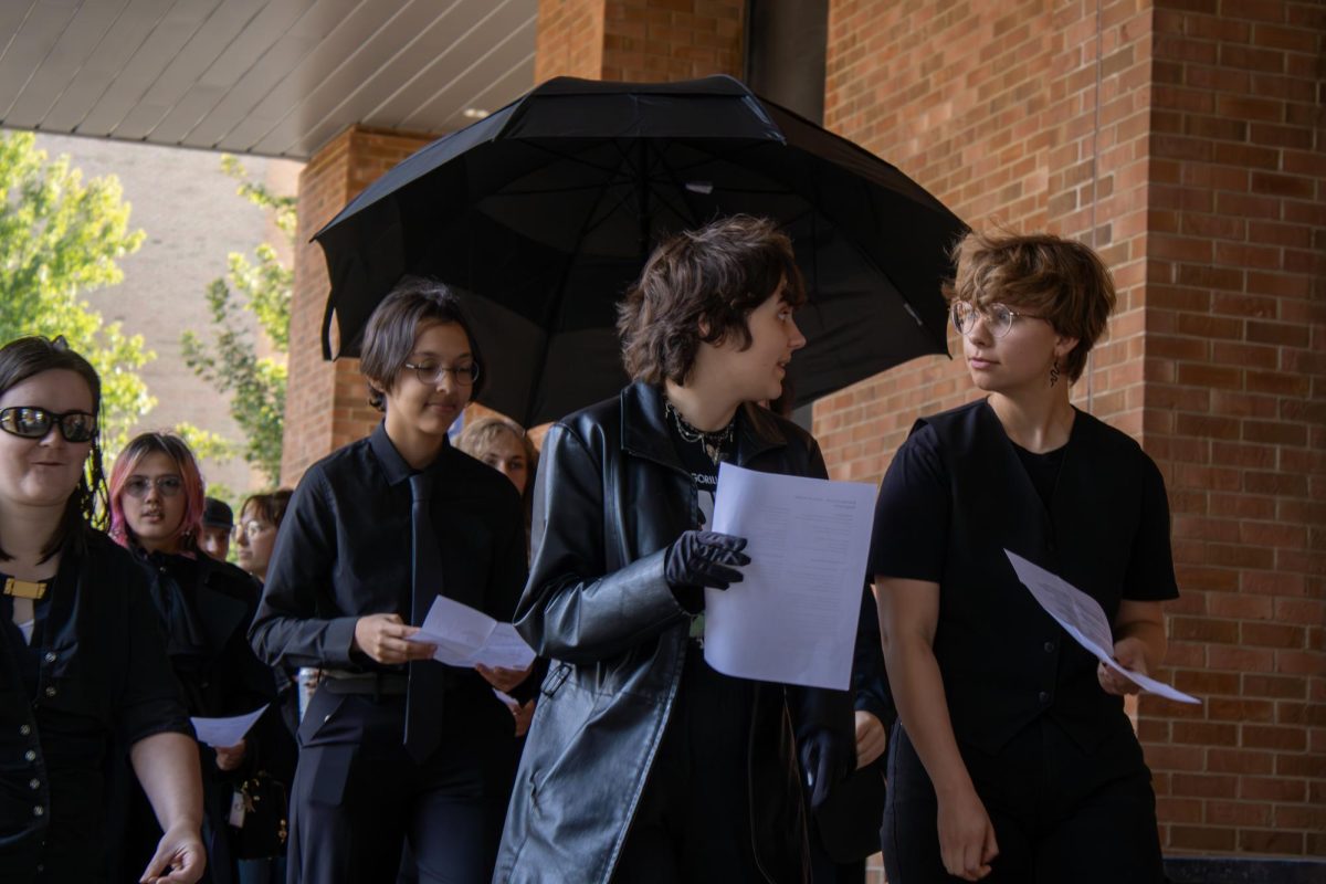 Kent students walk past the student center as they march to the Women's Center during the "We Wear Black" protest on Wednesday, August 27th, 2025.