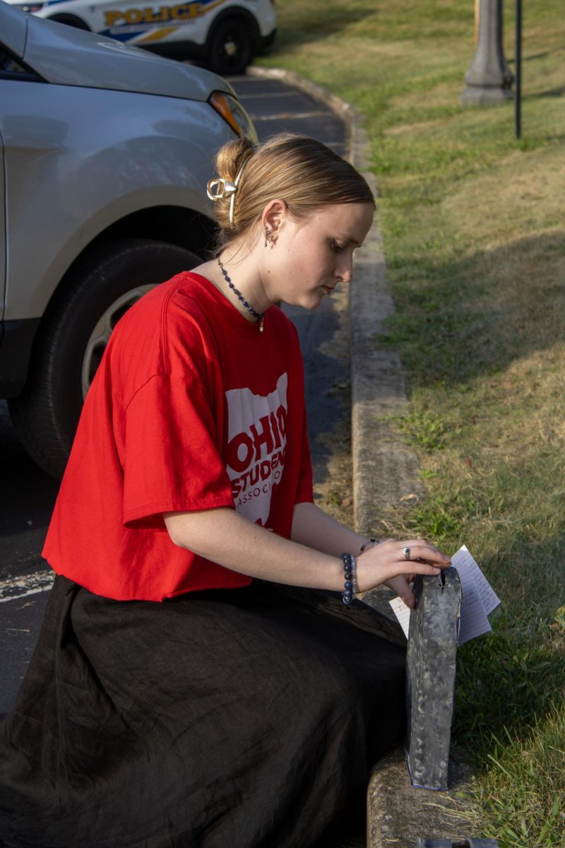 Ohio Student Association president, Grace Goodin, puts notecards that protestors wrote on in the Women's Center gravestone box on Wednesday, August 27th, 2025. 