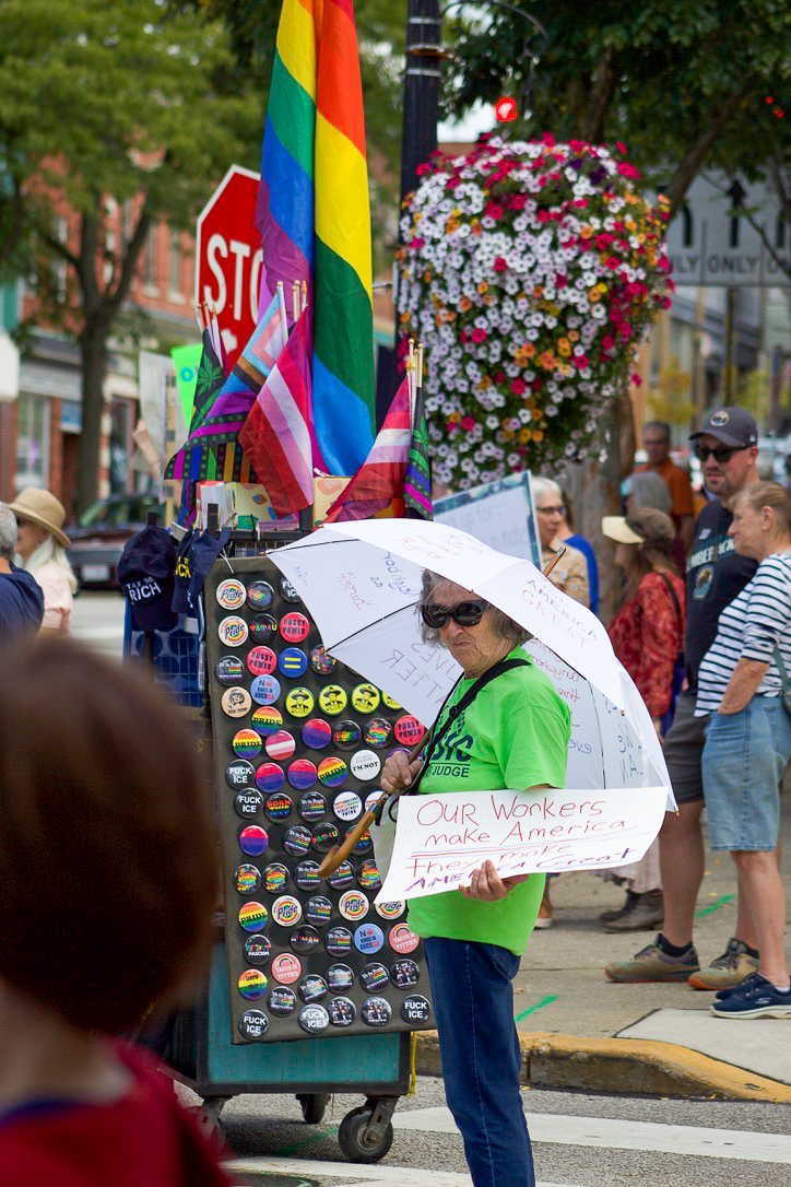 Caroline Wilson, 77, holds up a sign and a decorated umbrella at the 'Workers Over Billionaires' protest located near the Kent gazebo on Monday, Sept. 1, 2025.