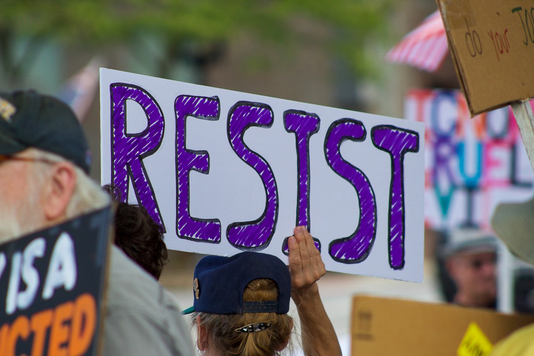 Demonstrator holds up a sign reading "Resist" at the 'Workers Over Billionaires' protest located near the Kent gazebo on Monday, Sept. 1, 2025.