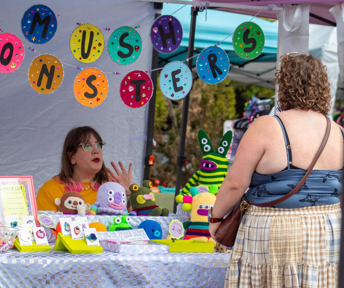 Emily Watroba, owner of Mush Monsters, chats with a customer shopping at the Mabon Market pop-up event on Sept. 21, 2025.
