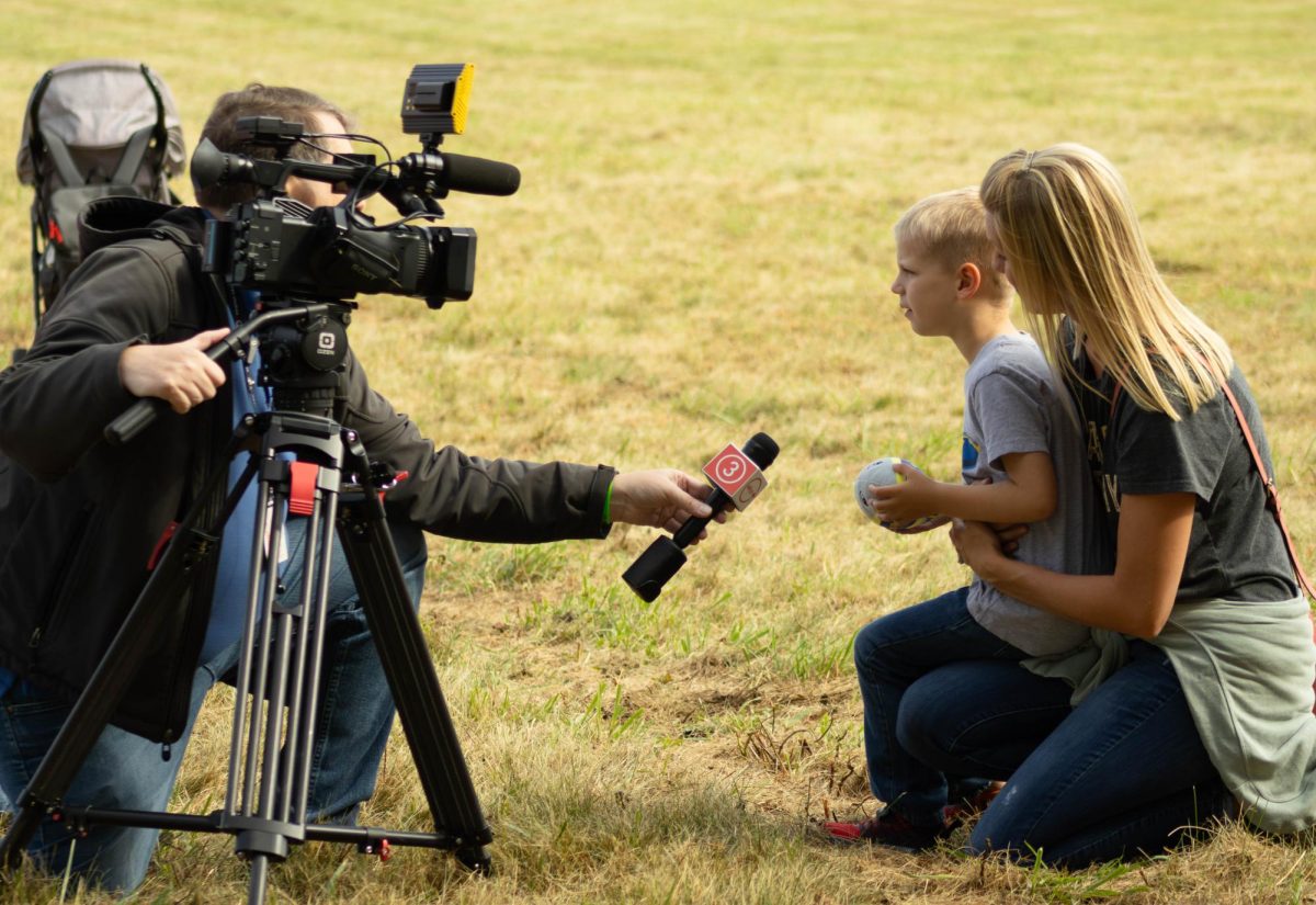 Amanda Price and her son Emerson are interviewed by a TV station about the Goodyear Blimp at Kent States annual Engineering & Aeronautical Expo on Sept. 6, 2025.