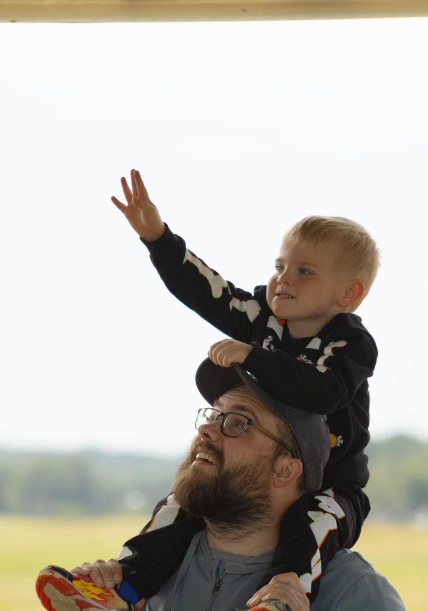 Andrew Bugaj reaches up to touch the Goodyear Blimp at the Engineering & Aeronautical Expo on Sept. 6, 2025.