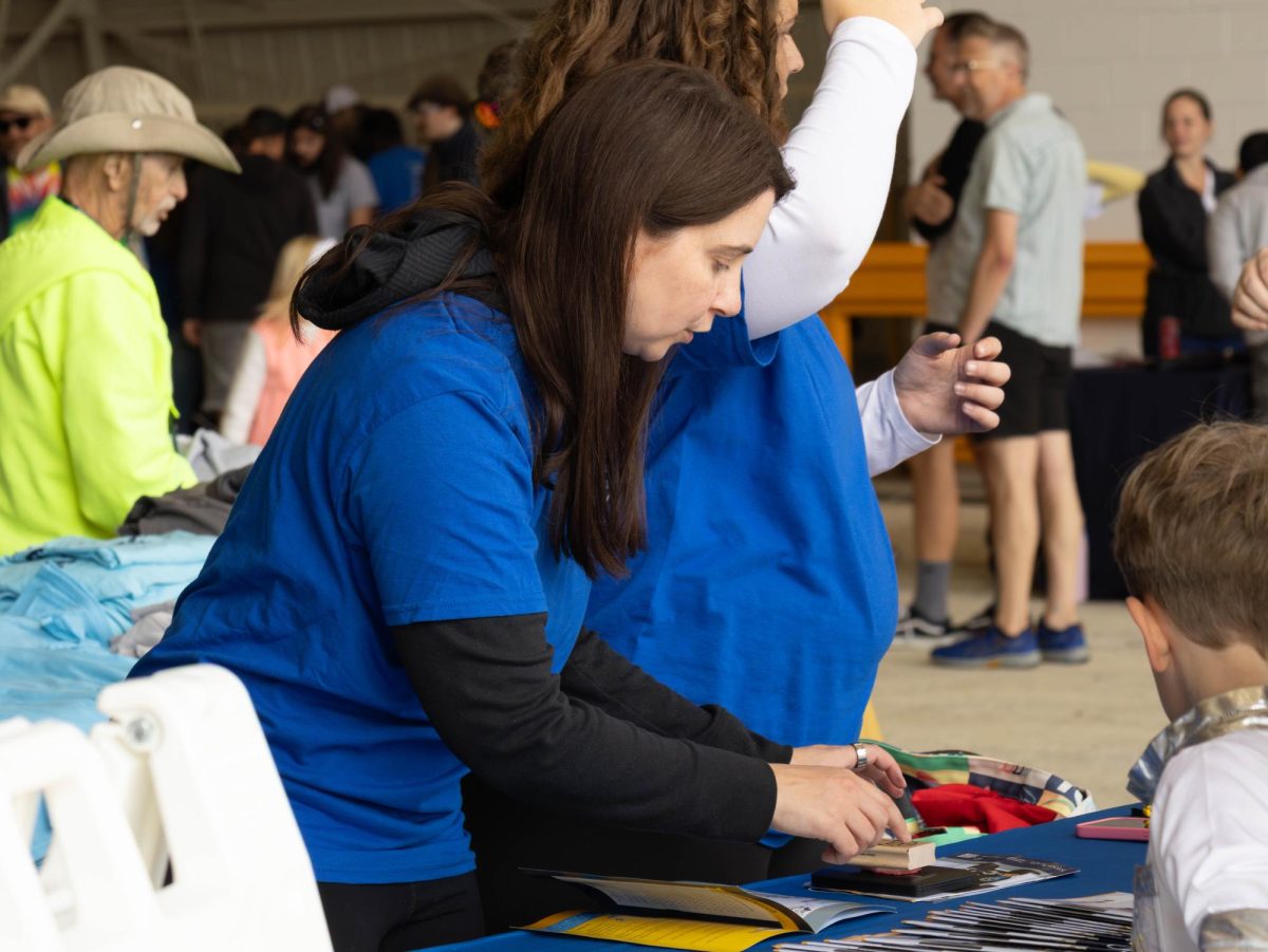 Kasey Monda, an academic advisor for the College of Engineering & Aeronautics, helps a child with an activity at the annual Engineering & Aeronautics Expo on Sept. 6, 2025.