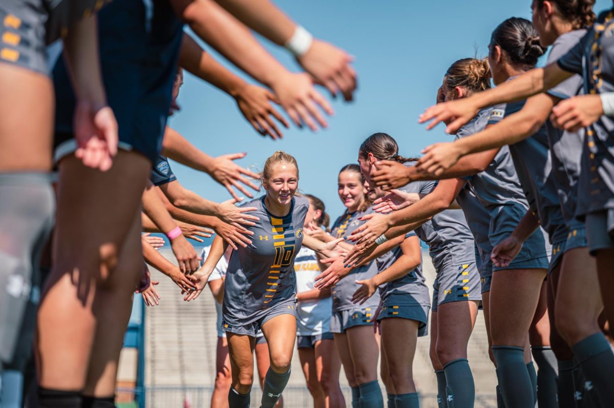Kent sophomore Addy Cusick runs through the tunnel made up of her teammates as they prepare for their game against Buffalo on Sunday, Sept. 28, 2025.