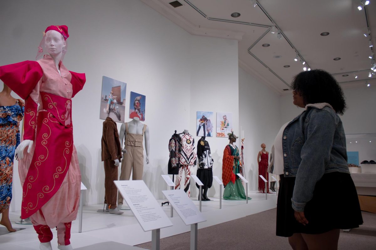 Kent freshman, Gia McKinley, photography major, admires the many outfits shown on display at the new exhibit called "A Meeting of Cultures: Fashioning North Africa" in the Fashion Museum on Saturday, Sept 6, 2025.