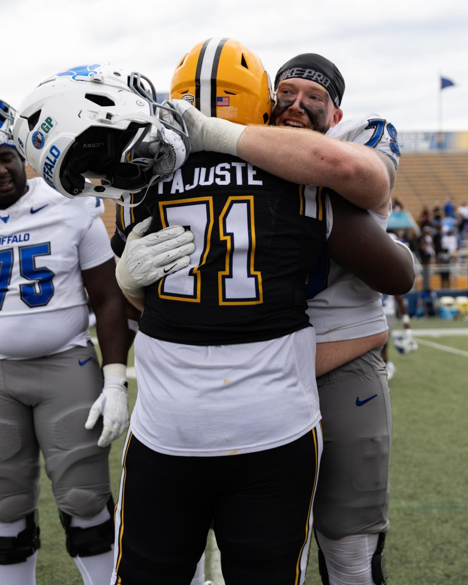 Kent State redshirt senior Matt Pajuste, 71, embraces former teammate Trevor Brock, 79, after kents 31-28 loss against Buffalo on Sept. 13, 2025.