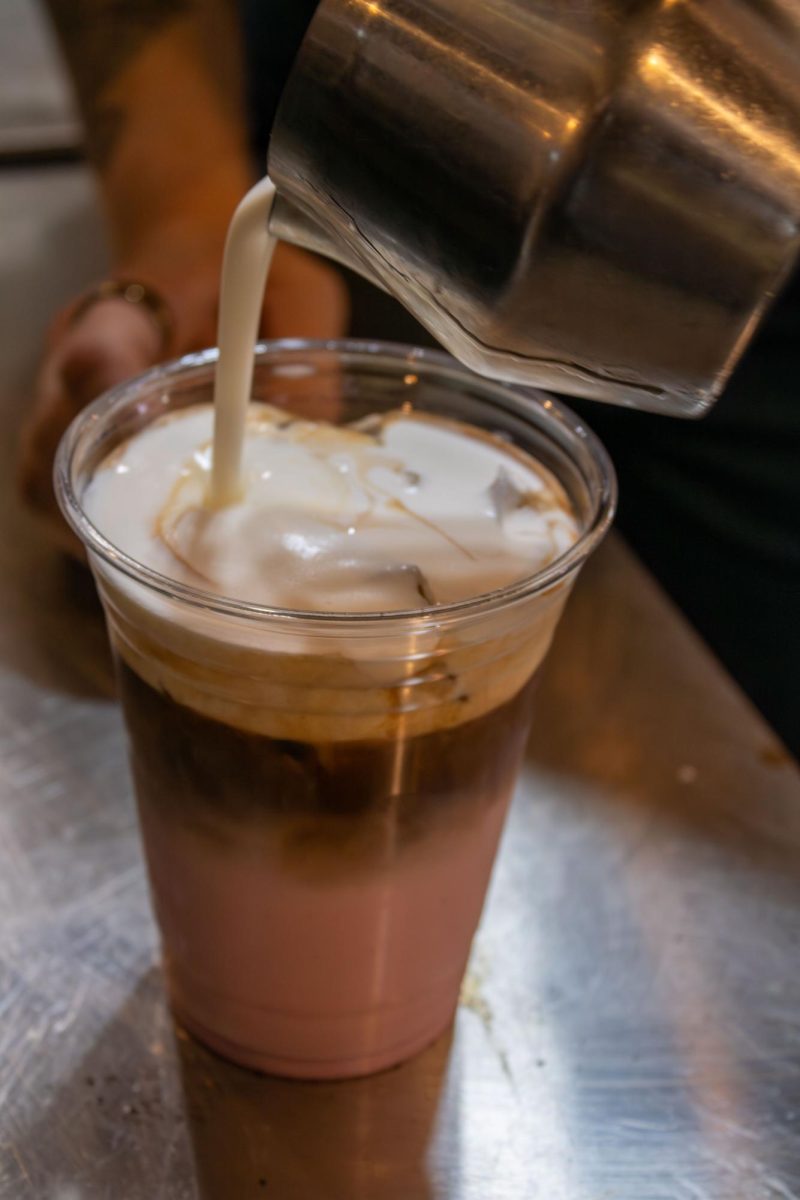 Beth Budzar, Scribbles Coffee Company manager, pours the sweet foam to top off the Her Latte on Saturday, Oct. 18, 2025.