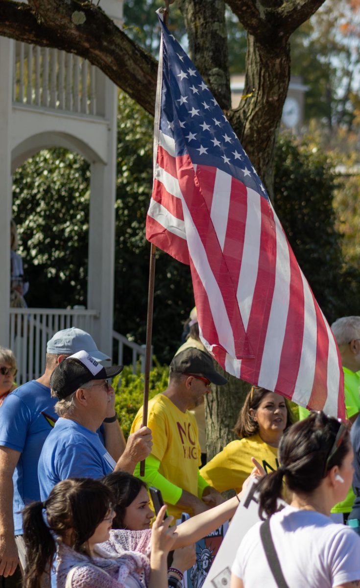 Ravenna resident, Val Rousey, holds an American flag before the start of the No Kings Protest on Saturday, Oct. 18, 2025