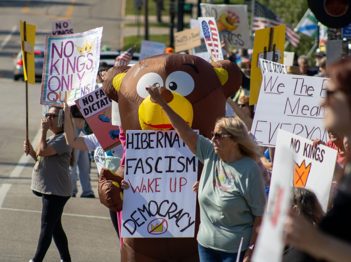 Protesters stand on East Main Street as they scream and hold up their fists during the "No Kings" protest on Saturday, Oct. 18, 2025.