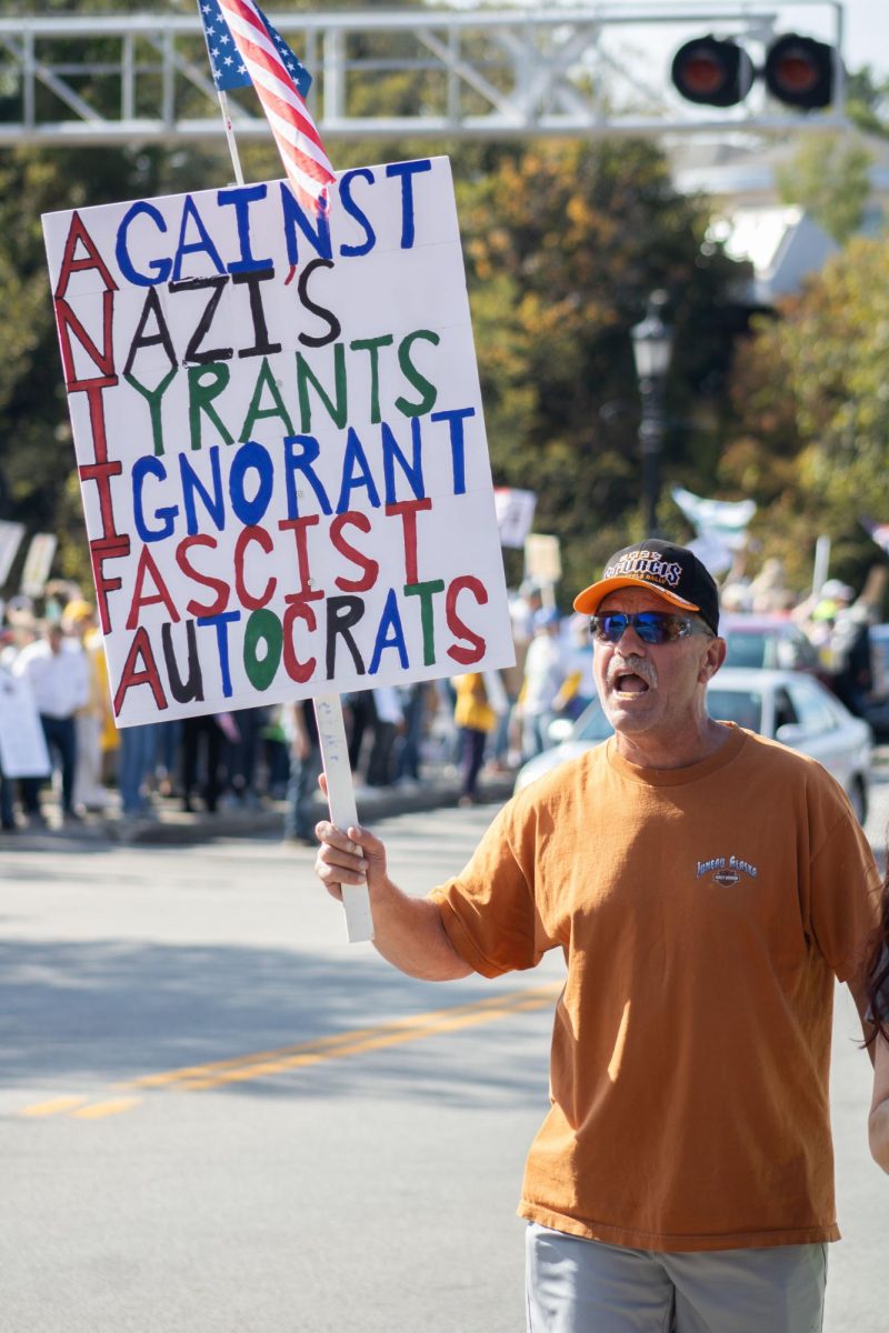 An attendee of the "No Kings"protest screams a chant as he walks up East Main Street on Saturday, Oct. 18, 2025.